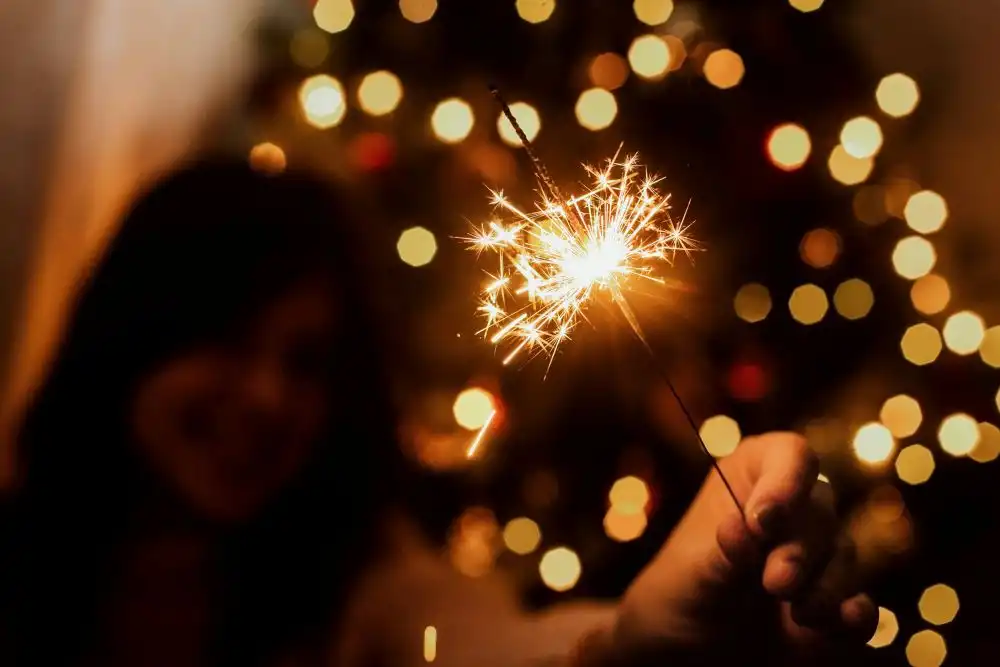 Persone che festeggiano il Capodanno a casa con stelle filanti e decorazioni natalizie