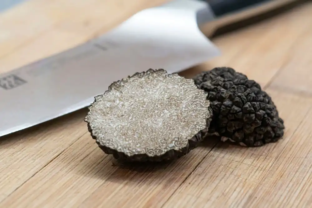 Tartufo bianco tagliato in due parti su un tavolo di legno